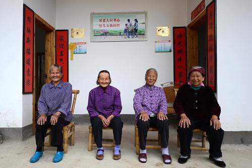 在安遠縣三百山鎮(zhèn)烏石村感恩苑,80歲的低保老人陳桂娣(左一)、81歲的低保老人劉招娣(左二)、71歲的特困老人唐壽娣(右二)和特困老人鄧天娣在新房前合影(5月9日攝)。在農(nóng)村危舊土坯房改造工作中,江西安遠縣創(chuàng)新工作思路,在社區(qū)建設“感恩苑”,讓孤寡老人、五保老人等免費入住。目前該縣已建成的19處“感恩苑”解決千余名老人的住房難題。據(jù)了解,安遠縣共有農(nóng)村危舊土坯房30028戶,需要改造的有23764戶。其中,“兩紅”(在鄉(xiāng)退伍紅軍戰(zhàn)士和紅軍失散)人員、五保戶、低保戶、貧困殘疾人等困難群眾占31.4%。2012年6月,《國務院關(guān)于支持贛南等原中央蘇區(qū)振興發(fā)展的若干意見》出臺后,農(nóng)村危舊土坯房改造隨之展開。新華社記者 周科攝