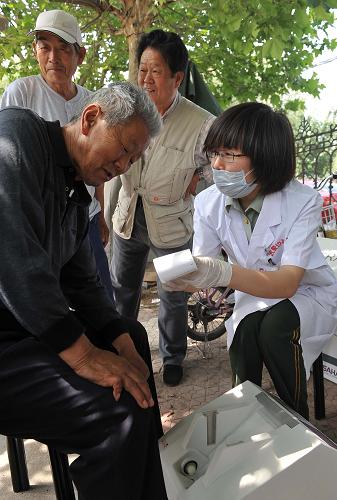 5月16日,山東邊防總隊(duì)醫(yī)院醫(yī)務(wù)人員為居民檢測骨密度。新華社記者 朱崢 攝