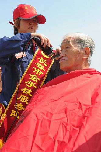 5月16日,一位“金手杖”殘疾志愿服務(wù)者(左)在為市民理發(fā)。新華社記者張楠攝
