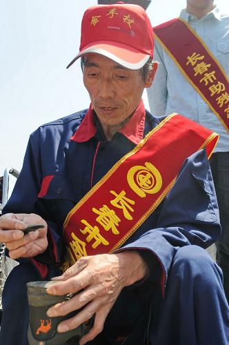 5月16日,一位“金手杖”殘疾志愿服務(wù)者在為市民修鞋。新華社記者張楠攝