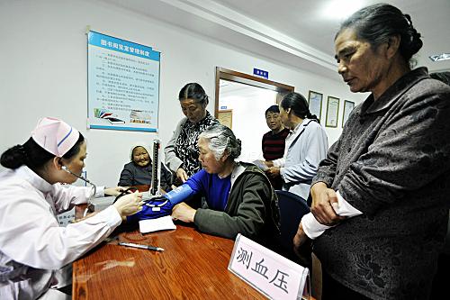5月17日,在舟山市岱山縣衢山鎮(zhèn)萬良社區(qū)田涂村,醫(yī)務(wù)人員為患者測量血壓。新華社記者 徐昱 攝