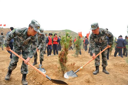 5月17日,解放軍官兵和學(xué)生在參加植樹活動。新華社記者 陳曄華 攝