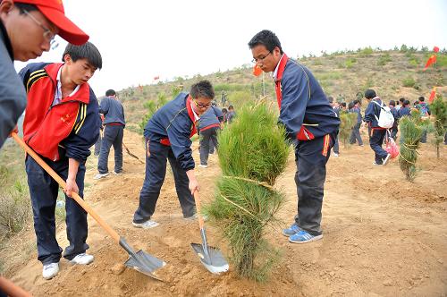 5月17日,青年學(xué)生在參加植樹活動。新華社記者 陳曄華 攝
