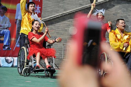 5月19日,在寧夏回族自治區(qū)銀川市街頭,銀川市殘疾人藝術(shù)團(tuán)的成員正在表演節(jié)目。新華社記者 彭昭之 攝