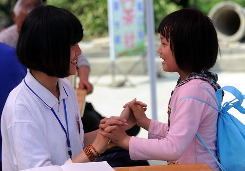 5月13日,在雅安市蘆山縣中國科學(xué)院心理研究所先鋒社區(qū)工作站的“心靈茶社”,一名心理援助志愿者在和災(zāi)區(qū)兒童做游戲。新華社記者 李曉果 攝