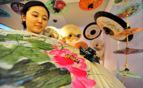 5月23日,參觀者在江西展廳觀看展出的婺源油紙傘。當日,首屆湘贛鄂皖非物質(zhì)文化遺產(chǎn)聯(lián)展在湖北美術(shù)館開展,展出600余張經(jīng)典圖片和數(shù)百件非遺精品實物,系統(tǒng)地為廣大民眾介紹湖北、湖南、江西、安徽四省共200多個非遺項目和非遺保護現(xiàn)狀。其間還邀請四省共40位傳統(tǒng)美術(shù)和傳統(tǒng)技藝類的非遺項目的代表性傳承人進行現(xiàn)場展示。新華社記者 肖藝九 攝