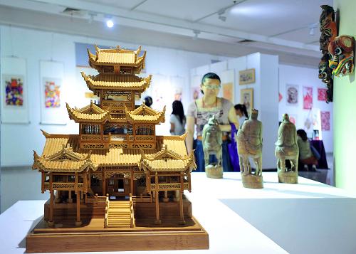 5月23日,參觀者在湖南展廳觀看土家族竹雕展品。新華社記者 肖藝九 攝