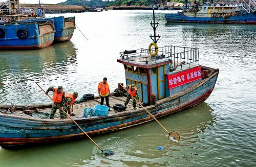 5月23日,福建省連江縣邊防民警在黃岐海域打撈海漂垃圾。新華社記者 張國(guó)俊 攝