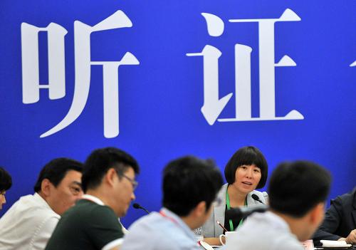 5月23日,北京市發(fā)展和改革委委員、聽證會主持人李素芳與聽證會參加人交流。新華社記者 李文 攝