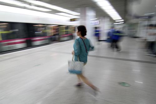 2013年5月28日,在上海世紀(jì)大道地鐵站,一名乘客匆忙趕車。新華社發(fā)(陳暐 攝)