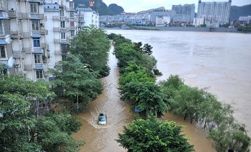 6月10日,在廣西柳州市濱江西路,汽車緊急駛離被淹路面。連日來,受上游強降雨影響,柳江水位出現(xiàn)暴漲。截至6月10日11時,柳江水位達82.7米,超過警戒水位0.2米。沿江街道被淹,部分商家和居民緊急轉(zhuǎn)移。新華社發(fā)(黎寒池 攝)
