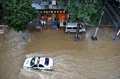 6月10日,在廣西柳州市濱江西路,一輛警車從被淹路面駛過。新華社發(fā)(黎寒池 攝)