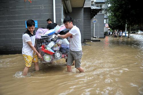 6月10日,在廣西柳州市濱江西路,居民在積水中轉(zhuǎn)移物品。新華社發(fā)(黎寒池 攝)