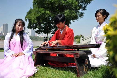 6月12日,在蘭州黃河岸邊端午活動現(xiàn)場,漢文化愛好者彈奏古琴。新華社記者 陳斌 攝