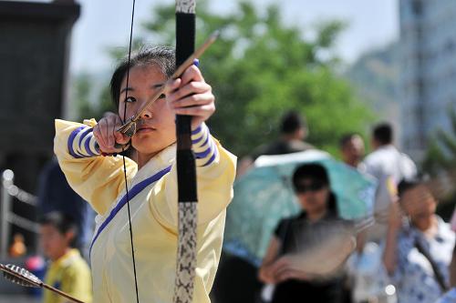 6月12日,在蘭州黃河岸邊端午活動現(xiàn)場,漢文化愛好者王雅文進行端午習射活動。新華社記者 陳斌 攝