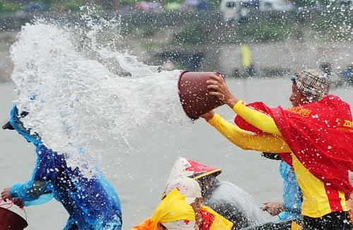 6月12日,參加閩臺對渡文化節(jié)暨蚶江海上潑水節(jié)的民眾在雨中潑水鬧端午。新華社記者 林善傳 攝