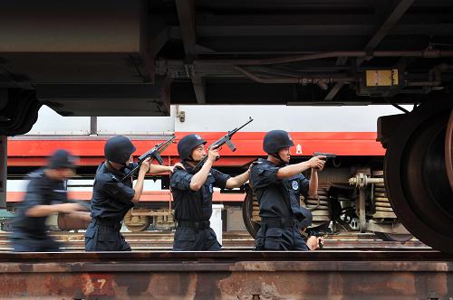 6月13日,在蘭州鐵路局銀川客運段的列車車庫內(nèi),銀川鐵路公安處特警支隊的隊員正在進行鐵路突發(fā)事件應急演練。新華社記者 彭昭之 攝