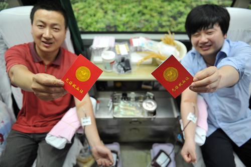6月14日,浙江省臨安市兩名市民在流動(dòng)采血車內(nèi)展示無償獻(xiàn)血證。當(dāng)日是第十個(gè)世界獻(xiàn)血者日,今年的主題為“每一份獻(xiàn)血都是生命的禮物”。在這個(gè)特殊的日子里,各地的愛心人士踴躍獻(xiàn)血,奉獻(xiàn)著自己的愛心。新華社發(fā)(胡劍歡 攝)