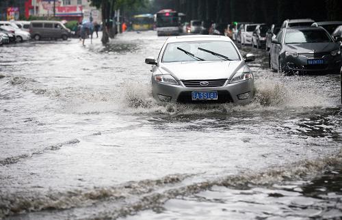 6月23日,車輛在南京街頭積水路段行駛。 新華社發(fā)