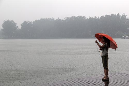 6月23日,在南京玄武湖畔,游客在雨中駐足拍照。新華社發(fā)(王勝濤 攝)