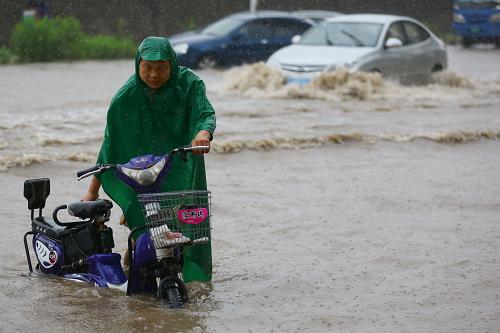 6月23日,行人在南京街頭冒雨出行。新華社發(fā)(韓華 攝)