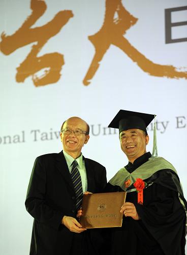 6月23日,身穿黑色學(xué)位服的煙臺(tái)麥特集團(tuán)總裁蓋方(右)接過(guò)前臺(tái)灣大學(xué)校長(zhǎng)李嗣涔頒發(fā)的證書(shū),成為首位接過(guò)兩岸EMBA證書(shū)的大陸學(xué)生。新華社記者 陶明 攝