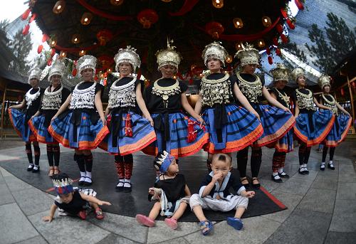 6月23日,在廣西臨桂縣義江緣景區(qū),白褲瑤族演員向游客展示白褲瑤族服飾。新華社發(fā)(劉杰 攝)