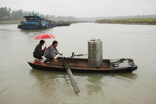 6月25日,渦河蒙城水域船民劃船運(yùn)送消防隊(duì)員提供生活用水。新華社發(fā)(胡衛(wèi)國(guó) 攝)