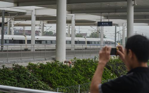6月26日,一位湖州市民在用手機拍攝高鐵湖州站內的高鐵調試列車。寧杭甬高鐵經(jīng)過一個月的試運行,即將正式開通,鐵路部門也已經(jīng)公布了7月1日寧杭甬高鐵列車運行班次和票價。作為長三角沿線重要鐵路項目的寧杭甬高鐵開通后,南京、杭州、寧波三地將形成“一小時交通圈”,地處浙北的湖州市也將步入“高鐵時代”。新華社記者 徐昱 攝