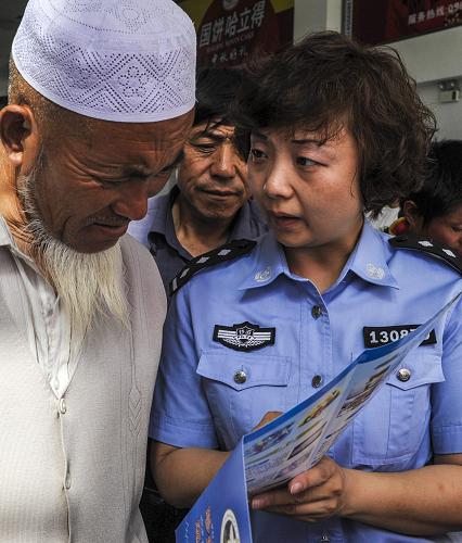 6月26日,烏魯木齊鐵路公安處民警井珉在給旅客介紹禁毒知識。新華社記者 趙戈 攝