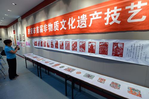 6月27日,觀眾在西安市群眾藝術(shù)館觀看參加展示的剪紙作品。當(dāng)日,來自西安各地的36位民間藝人在市群眾藝術(shù)館參加“西安市首屆非物質(zhì)文化遺產(chǎn)傳統(tǒng)技藝大賽”剪紙刻紙項(xiàng)目的比賽,比賽分為雕塑類、民間繪畫類、傳統(tǒng)女紅手工技藝類和剪紙刻紙類等項(xiàng)目。此次比賽旨在為非遺代表性傳承人和工藝美術(shù)大師技藝的交流和展示提供平臺,同時為非物質(zhì)文化遺產(chǎn)愛好者提供交流學(xué)習(xí)的機(jī)會。新華社記者 李一博 攝