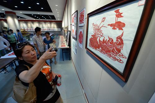 6月27日,觀眾在西安市群眾藝術(shù)館觀看參加展示的剪紙作品。新華社記者 李一博 攝
