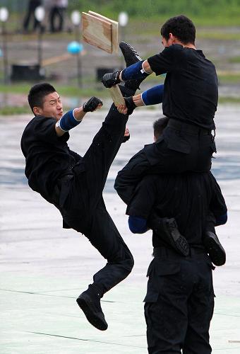 6月27日,特警隊(duì)員在演練中飛腿踢木板。新華社記者 凡軍 攝