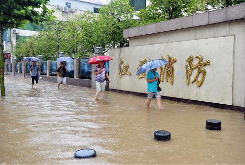 6月28日,南昌市民涉水經(jīng)過撫生路。新華社發(fā)(熊家福 攝)