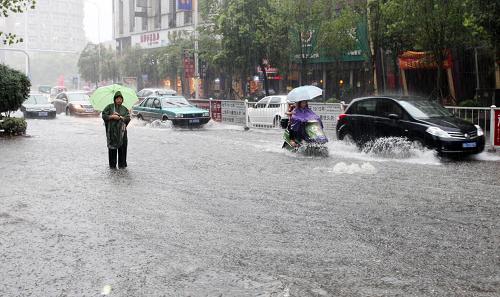 6月28日,市民冒雨行進在江西上饒城區(qū)積水的道路上。新華社發(fā)(夏內(nèi)信 攝)