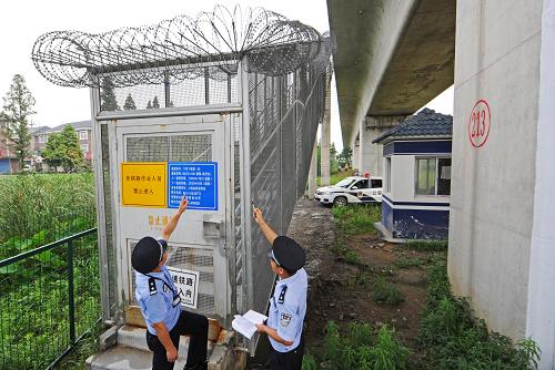6月29日,浙江德清鐵路派出所的兩位民警在檢查寧杭甬高鐵一處應(yīng)急疏散通道的安全防護(hù)設(shè)施。新華社記者譚進(jìn)攝