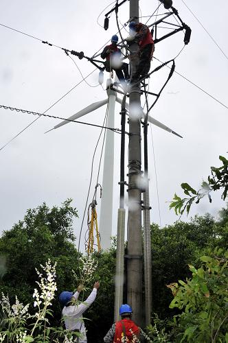 7月12日,國家電網(wǎng)山東煙臺棲霞供電公司的搶修人員在搶修35千伏觀里一線6號桿上的故障。新華社發(fā)(任夢雪 攝)