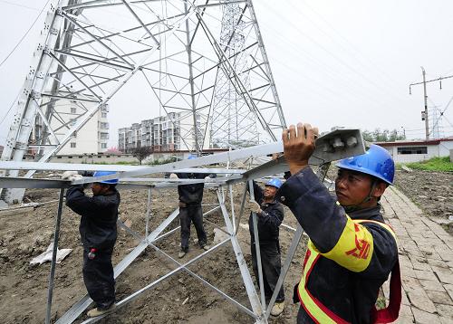 7月12日,電力公司工人在緊張施工。近日,津秦客運(yùn)專(zhuān)線天津?yàn)I海段供電工程的最后一座基塔已完成組塔,標(biāo)志著該段供電工程已進(jìn)入收尾階段。津秦客運(yùn)專(zhuān)線是連接環(huán)渤海經(jīng)濟(jì)區(qū)的重要經(jīng)濟(jì)紐帶,建成后北可形成貫通東北、華北、華東、中南地區(qū),便捷、高效、節(jié)能環(huán)保的快速客運(yùn)通道。津秦線線路全長(zhǎng)約258公里,其中天津段正線長(zhǎng)65公里。新華社記者 毛振華 攝
