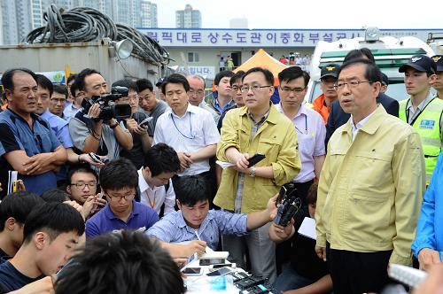 7月17日,在韓國首爾,首爾市長樸元淳(前排右一)在救援現(xiàn)場接受媒體采訪。其余6人失蹤。新華社發(fā)