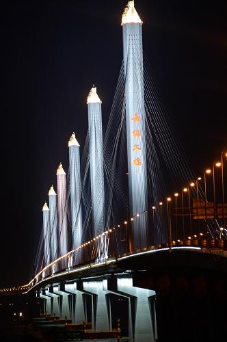 嘉紹跨海大橋亮燈夜景(7月17日攝)。 嘉紹大橋指揮部7月16日宣布:嘉紹跨海大橋及南北接線工程將于2013年7月19日零時零分正式通車運行。嘉紹跨海大橋為六塔獨柱雙幅四索面鋼箱梁斜拉橋,其中主航道橋為六塔五孔全長2680米的設(shè)計,建成以后將是目前世界上最長最寬的多塔斜拉橋,主通航孔滿足通航3000噸級集裝箱船的需要。嘉紹跨海大橋于2008年底動工,是繼杭州灣跨海大橋之后第二座跨杭州灣大橋,總投資約139億元。其中跨越杭州灣部分長約10公里,按高速公路標準建設(shè),設(shè)計時速為100公里。嘉紹跨海大橋建成后,浙江紹興到上海的車程將縮短近一半。新華社記者 徐昱 攝