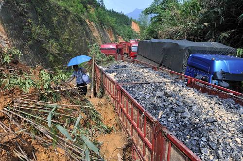 8月21日,一位被困司機(jī)家屬?gòu)膹V西武(宣)平(南)公路一段塌方路段通過(guò)。記者8月21日在廣西桂平市紫荊鎮(zhèn)花蕾村桂平塌方現(xiàn)場(chǎng)指揮部了解到,因泥石流塌方及交通事故等原因,從8月17日至21日15時(shí),有210多輛汽車、500余人被困武平二級(jí)公路。桂平塌方現(xiàn)場(chǎng)指揮部組長(zhǎng)、廣西壯族自治區(qū)公路管理局副局長(zhǎng)韋昌永告訴記者,武平公路桂平路段多處塌方,造成22公里交通中斷,最大最難的有5個(gè)點(diǎn),其中4個(gè)缺口,一個(gè)泥石流。為了盡快疏散被困車輛,有關(guān)部門相互配合緊急施工,8月20日晚連夜施工至8月21日凌晨5時(shí),截至目前,塌方路段已搶通19公里,疏通了近50輛被困車輛,100余名司機(jī)脫困。新華社記者 周華 攝