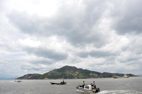 8月21日,福建寧德三都澳海面上烏云滾滾,漁民們忙著轉(zhuǎn)移漁排上的物資,回港避風(fēng)。新華社記者 郭圻 攝