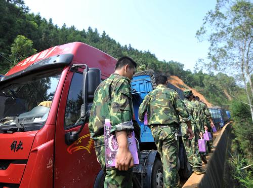 8月21日,廣西武(宣)平(南)公路桂平塌方現(xiàn)場(chǎng),民兵應(yīng)急分隊(duì)在給被困司機(jī)送去八寶粥。 記者21日從廣西桂平市紫荊鎮(zhèn)花蕾村武平公路桂平塌方現(xiàn)場(chǎng)指揮部了解到,除設(shè)置應(yīng)急醫(yī)療點(diǎn)、救助點(diǎn)外,該指揮部從19日開(kāi)始每天安排專(zhuān)人徒步將飲用水、食品、藥品送達(dá)被困人員手中,確保司機(jī)們有飯吃、有水喝。新華社記者 周華 攝