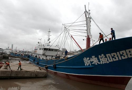 8月21日,在浙江省寧波市鎮(zhèn)海區(qū)水產(chǎn)碼頭,海警官兵和工作人員加固纜繩防范臺風“潭美”。新華社發(fā)(索向魯 攝)