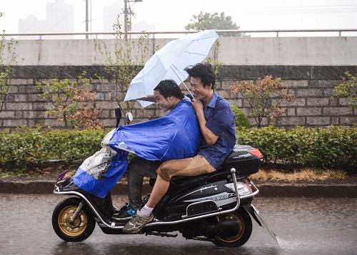 8月21日,臺(tái)州市天臺(tái)縣兩名騎車(chē)人冒著大雨前行。新華社記者 徐昱 攝