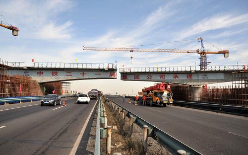 8月21日,蘭新鐵路第二雙線烏魯木齊樞紐內(nèi)鐵路大橋進(jìn)行跨高速公路轉(zhuǎn)體合龍作業(yè)。當(dāng)日,蘭新鐵路第二雙線在烏魯木齊樞紐內(nèi)與連霍高速公路交匯處,一座長(zhǎng)140米、重3500噸的鐵路大橋經(jīng)過兩個(gè)小時(shí)的高空轉(zhuǎn)體后,兩片橋梁跨越連霍高速公路順利合龍。采用這種施工方法,避免了傳統(tǒng)施工方式需要對(duì)高速公路實(shí)施約100天封閉及限行措施的弊端,也加快了施工進(jìn)度。蘭新鐵路第二雙線東起甘肅蘭州,西至新疆烏魯木齊,全長(zhǎng)1776公里,是新疆首條高速鐵路,預(yù)計(jì)2014年底建成通車。新華社記者 符曉波 攝