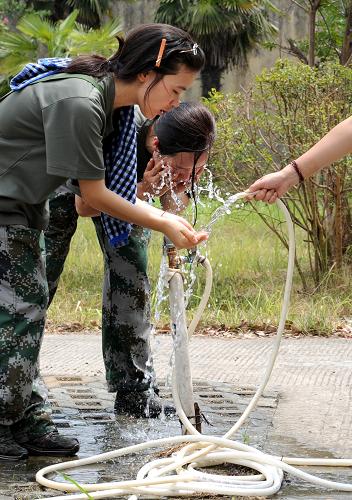 8月20日,兩名實(shí)訓(xùn)隊(duì)員回到營(yíng)地吃午飯前,在水龍頭邊接水洗臉。新華社記者 孫參 攝