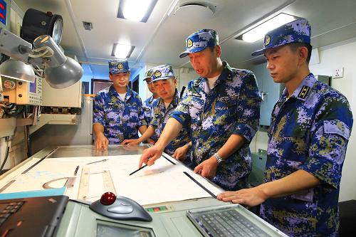 8月22日,海軍艦艇編隊(duì)指揮員魏鋼少將(右二)在青島艦海圖室布署編隊(duì)航行計(jì)劃。新華社記者 查春明 攝