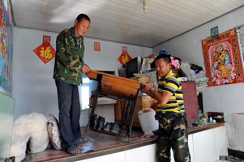 8月22日,黑龍江省大慶市肇源縣二站鎮(zhèn)蓮花泡村的村民在轉(zhuǎn)移家具。新華社發(fā)(邵國良 攝)