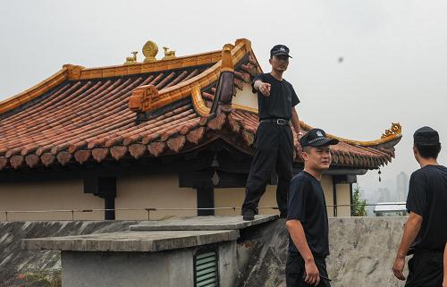 8月22日,深圳沙河執(zhí)法隊(duì)的工作人員準(zhǔn)備翻墻進(jìn)入涉嫌違建的美加廣場(chǎng)DE座屋頂。新華社記者 毛思倩 攝
